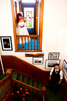 This bride peeks in on her future husband from a balcony with stained glass light hoping he doesn't see her.