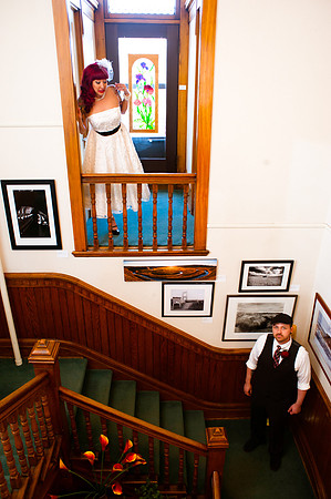 This bride peeks in on her future husband from a balcony with stained glass light hoping he doesn't see her.