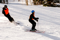 Image of an 81 year old blind man skiing with his guide following.  Wasatch Adaptive Sports at Snowbird