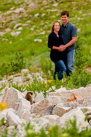 Couple pose with a wild yellow bellied marmot