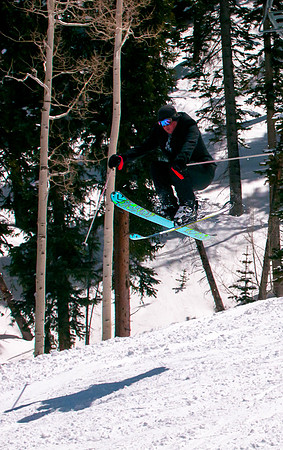 Groom in suit does iron cross with skis