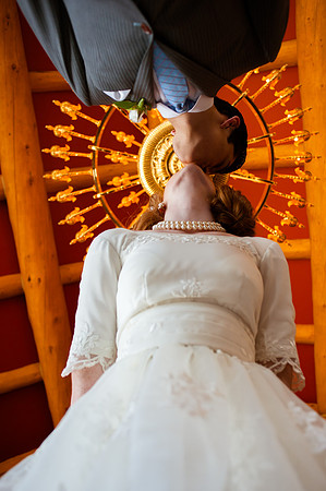 Snowbasin Wedding Inspiration-Bride and groom kiss under chandelier.