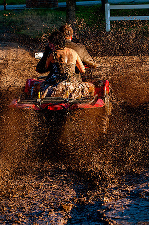 Bride and Groom drive 4 wheeler through mud
