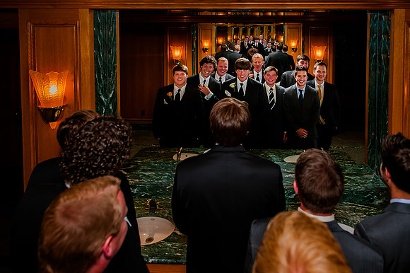 Groom and groomsmen getting ready in the mirror at Snowbasin
