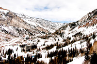 The Cliff Lodge at Snowbird with mountain background and blue, cloudy sky.