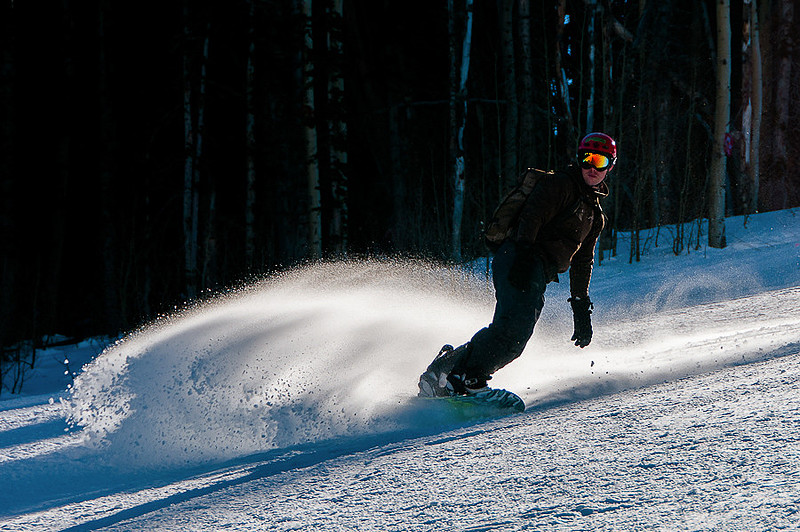 Snowboarder rides the wave.