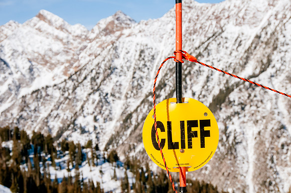 Cliff hazard sign with a cliff background at Snowbird