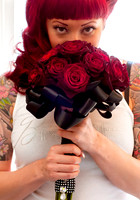 Bride smells red rose bouquet on wedding day