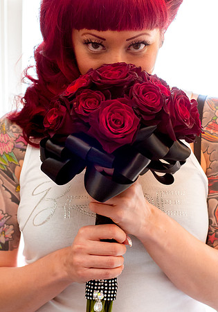 Bride smells red rose bouquet on wedding day