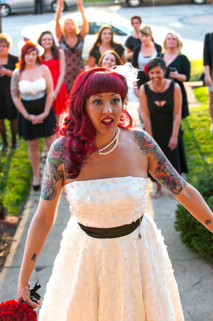 Tattooed bride with red hair getting ready to throw bouquet