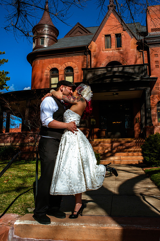 Tattooed bride and groom kiss in front of Eccles Art Center in Odgen, Utah