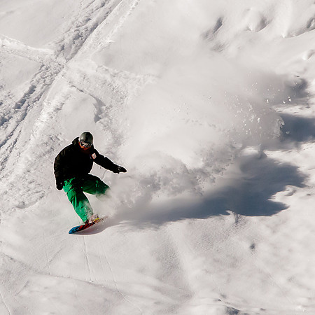 Snowboarder riding the surf made of powder at Snowbird with Wasatch Adaptive Sports